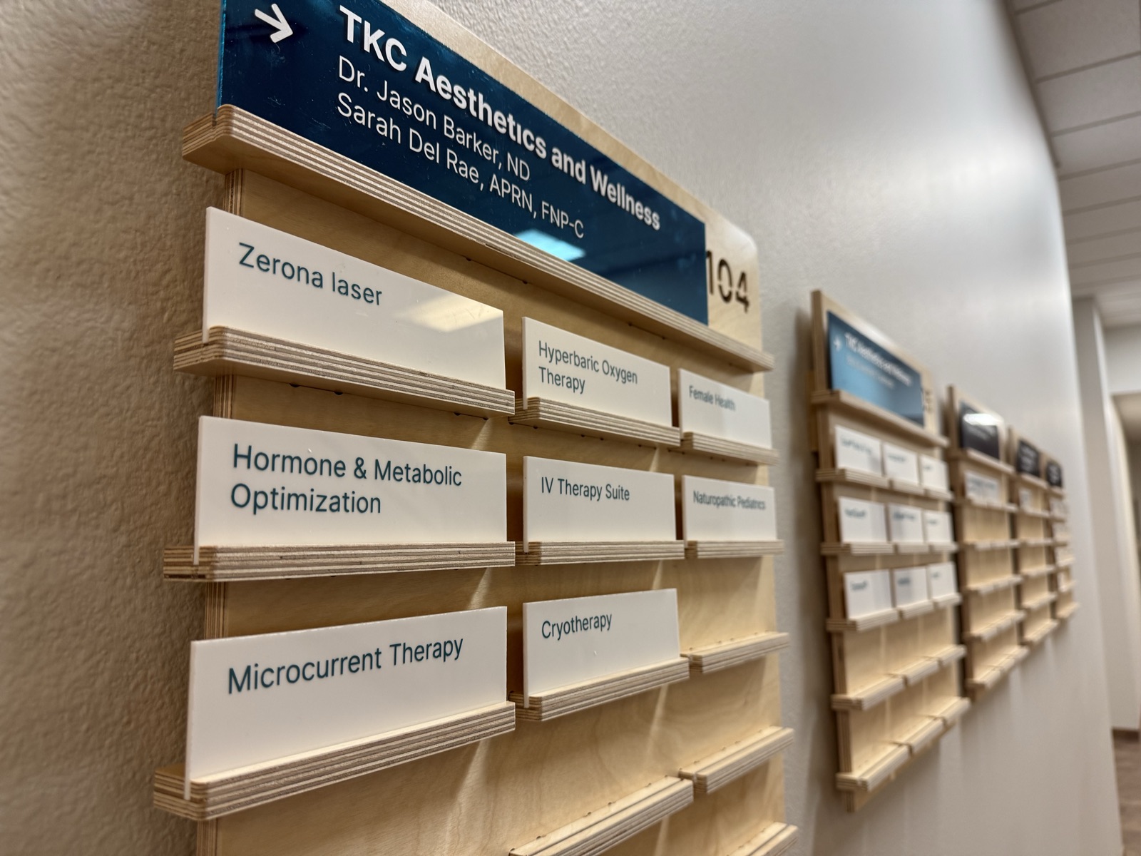 Custom birch wayfinding signage for TKC Aesthetics & Wellness