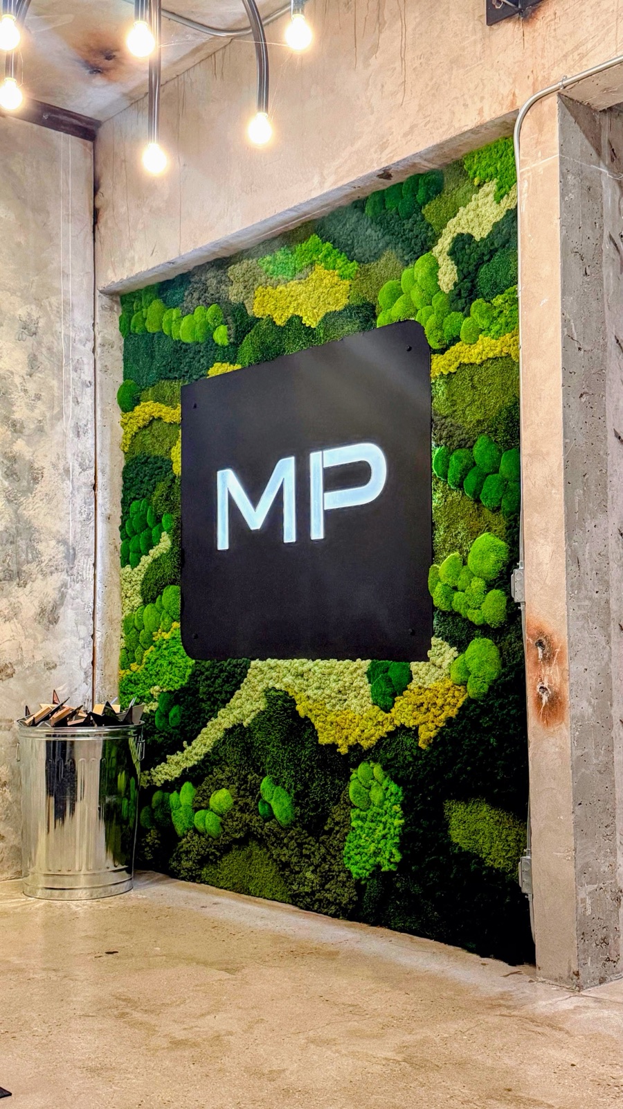 The Mitchell + Palmer moss wall in an industrial concrete studio